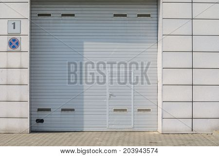 Large automatic up and over garage door with inclusion of smaller personal door.
