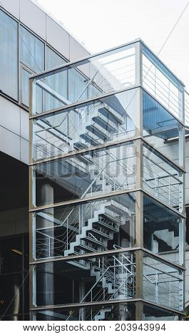 Metal fire escape outside apartment building for emergency. Staircase on the facade of a modern building