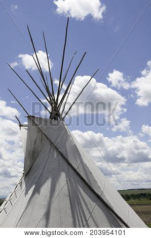 close up of white teepee with beautiful blue sky and white clouds