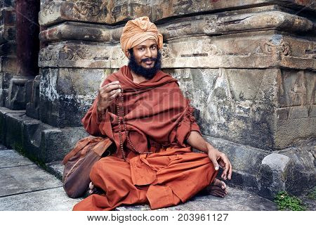 Naggar, India - July 17: Young Yogi Sits Near The Temple Of Krishna. Repeats The Secret Mantra Using