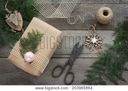 Preparation for Christmas holiday. Christmas Still life of giftbox decor twine fir tree twigs vintage scissors. Top view and copyspace. Flat lay.