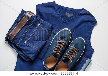 Fashionable men's clothing. Jeans and shoes on light background