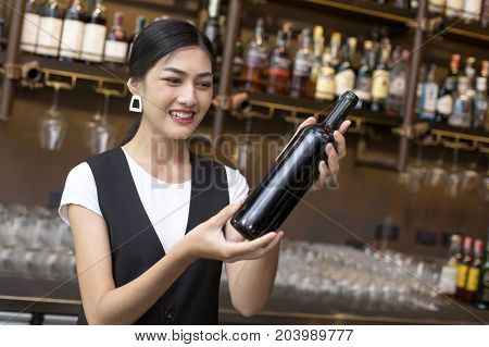 Young Asian Woman Waiter Restaurant Catering Service Happy Emotion. Woman Waiter Present Red-wine Fo