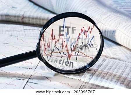 Magnifying glass shows the courses of ETF funds and shares