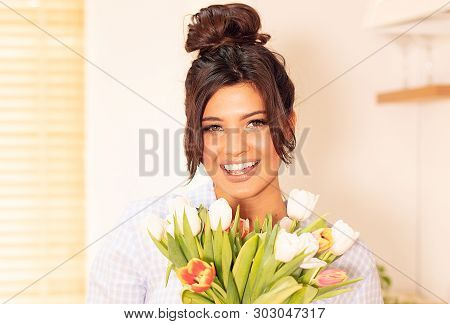 Beautiful Woman Holding Bounch Of Flowers, Smiling To The Camera. Happy Time.