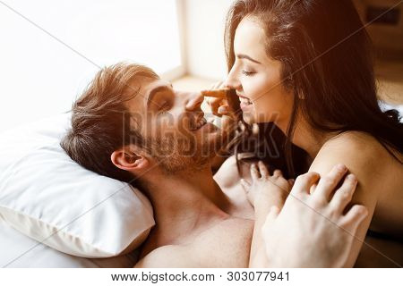 Young Sexy Couple Have Intimacy On Bed. Cheerful Nice Positive Happy People Smile To Each Other. She