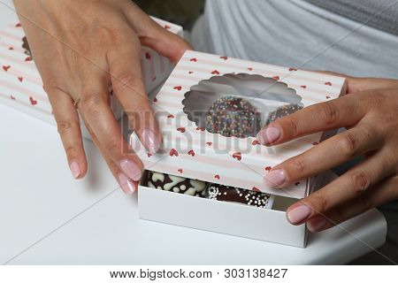 Cake Pops Decorated With A Bow Of Braid, Packed In A Gift Box. Woman Closes The Box.