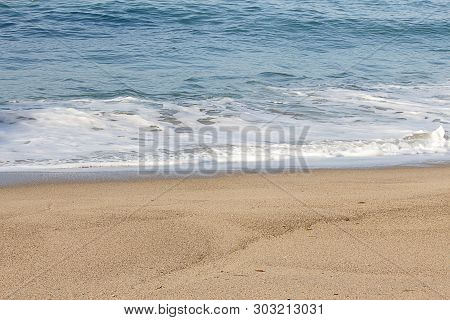 Foaming Breaking Wave And Backwash Foam On A Sandy Shoreline
