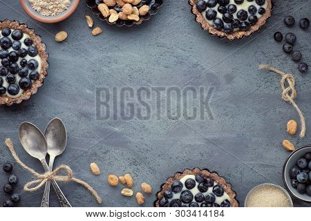 Top View On Wholegrain Blueberry Tarts With Vanilla Cream On Dark Background
