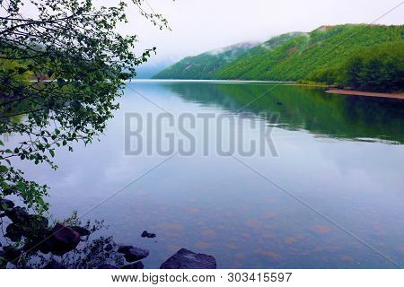 Lake With A Calming Ambiance Surrounded By Lush Forested Mountains During A Rainy Day Taken In Coldw