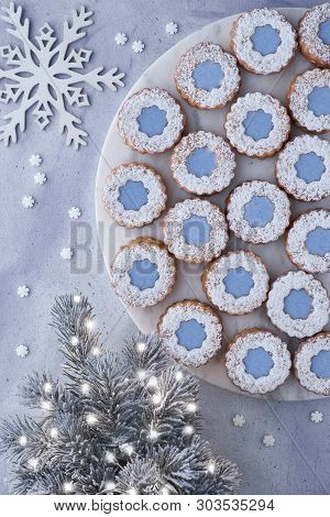 Flower Linzer Cookies With Blue Icing On White Marmor Board Set On Top Of Light Winter Background Wi