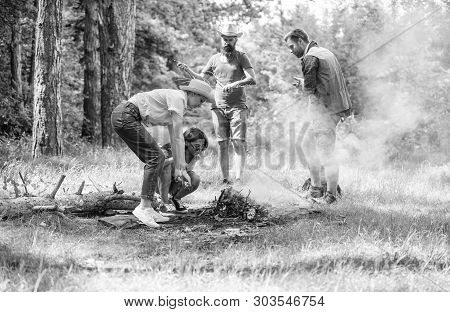 Friends Working As Team To Keep Bonfire. Company Camping Forest Prepare Bonfire For Picnic. Add Some