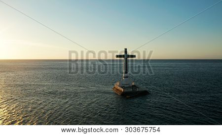 Catholic Cross In Sunken Cemetery In The Sea At Sunset, Aerial Drone. Large Crucafix Marking The Und