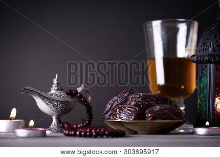 Ramadan Food And Drinks Concept. Ramadan Lantern With Arabian Lamp, Wood Rosary, Tea, Dates Fruit An