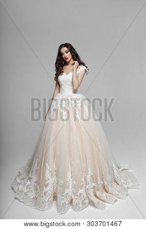 Beautiful Girl With Curly Hair In Wendding Dress, He Touches His Neck With His Hand, Isolated On A W