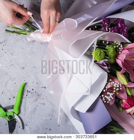 Florist Girl Works And Creates A Beautiful Modern Large Bouquet With Lilies. Femaly Hands. Top View,