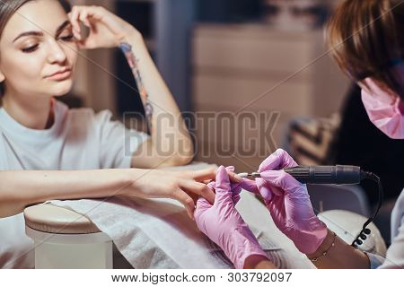 Pretty Young Cuctomer Is Resiving Manicure From Talanted Master.