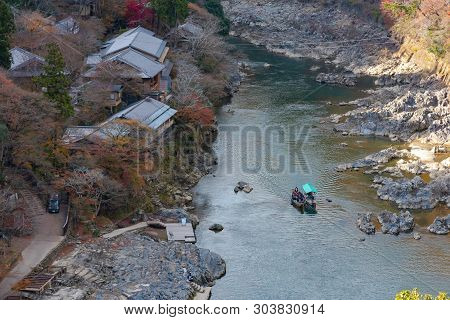Top View Of Hozugawa River With Japanese Traditional Wooden House , Boat And Autumn Foliage Colors F