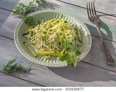 Light Salad With Fresh Katusta And Cucumbers With Spicy Herbs On A Round Lettuce Plate On A Plank Ta