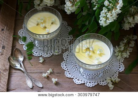 Panna Cotta With Robinia Flavor, Served With Honey And White Robinia Flowers. Rustic Style.