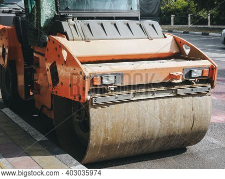 The Road Roller Stands Near The Curb On The Road. Road Service. Closeup Photo
