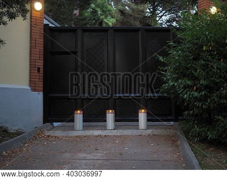 Barrier Retractable Bollards In Front Of The Iron Gates And With Burning Lanterns On The Walls