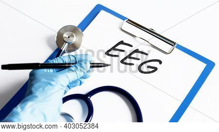 Paper With Text Eeg On A Table With Stethoscope. Medical Concept