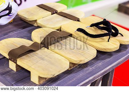 Traditional Japanese Wooden Footwear Geta On Dark Table Background.