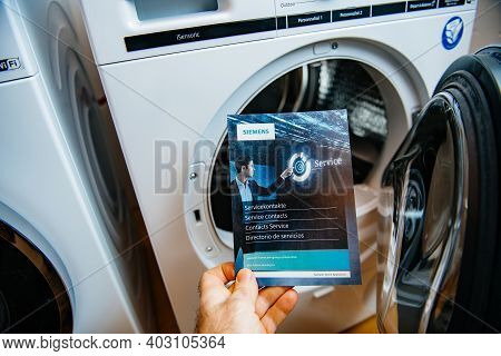 Paris, France - Jan 5, 2020: Pov Male Hand Holding Bosch Service Contact Flyer Advertising Informati
