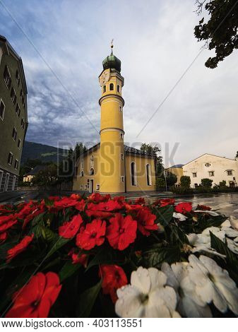 Red Flower Bouquet View Of Yellow Heiliger Antonius Church Chapel In Lienz East Tyrol Austria Alps E