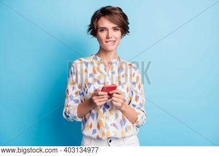 Photo Of Charming Flirty Pretty Sweet Young Lady Hold Phone Message Bite Theeth Lip Isolated On Blue