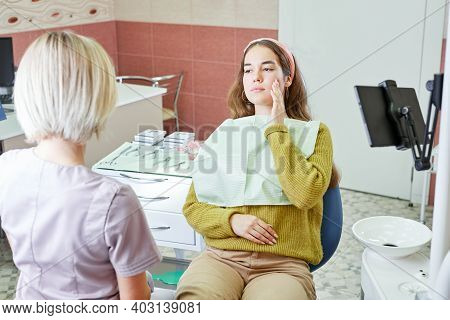 Young Woman Having Toothache And Sitting In A Dental Chair At Clinic. Female Patient With Toothache 