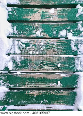 Snow On A Wooden Plank Floor Of An Open Terrace Close-up. Green Wooden Snowy Background.