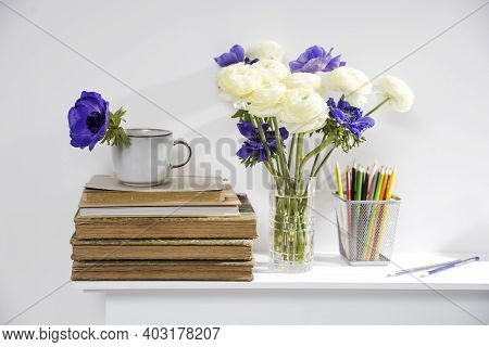 One Blue Anemone In A Cup In The Style Of The Seventies On The Table With Books As An Interior Decor
