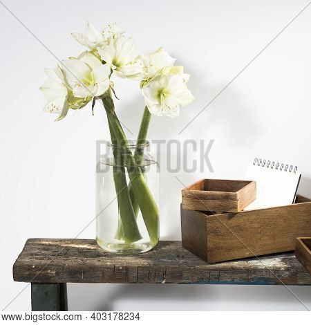 Bouquet Of White Lilies In A Tall Glass Vase On A Beige Table Against A Gray Wall. Copy Space. Fresh