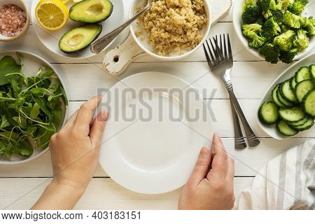 Cooking Healthy Salad. Female Hands Holdinh A Empty Plate. Green Detox Salad With Quinoa, Avocado, B