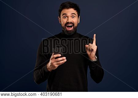 Attractive Man In Stylish High Neck Sweater, Raise Index Finger In Eureka Gesture Smiling Joyfully, 