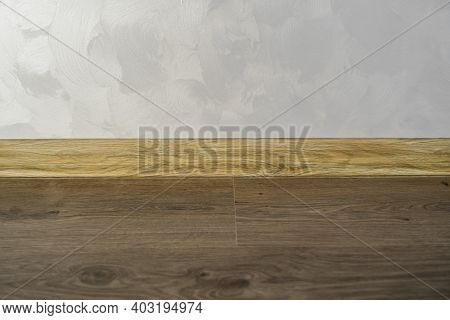 Laminate With Plastic Baseboard With A Wooden Texture. Newly Installed Wooden Laminate Flooring And 