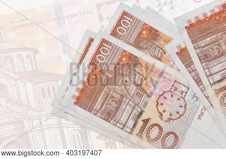 100 Croatian Kuna Bills Lies In Stack On Background Of Big Semi-transparent Banknote. Abstract Prese