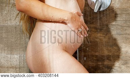 Beautiful Pregnant Woman With Big Belly Relaxing In Shower At Hotel Room And Massaging Her Body Conc