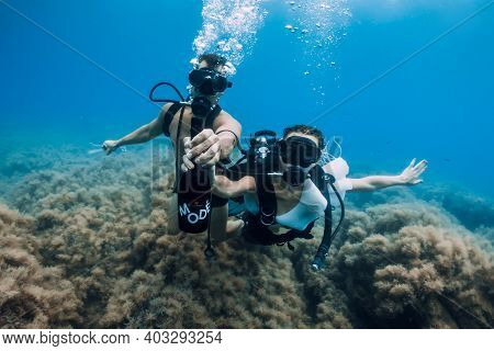 August 20, 2020. Anapa, Russia. Couple Of Scuba Divers Glides Underwater In Transparent Blue Sea. Sc