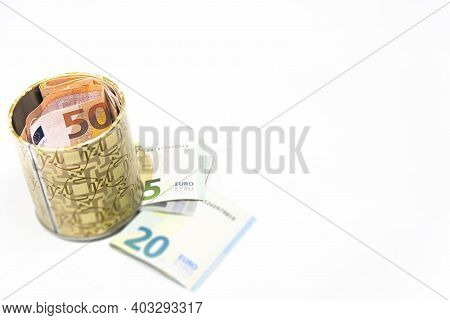Metal Piggy Bank With Euro Symbols For Saving Money. On A White Background With Euro Banknotes. Savi