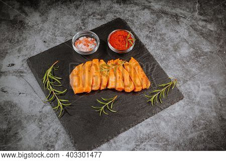 Chicken Fillet Thinly Sliced On A Black Ceramic Plate With Cooking Spices, Chili And Rosemary. Top V