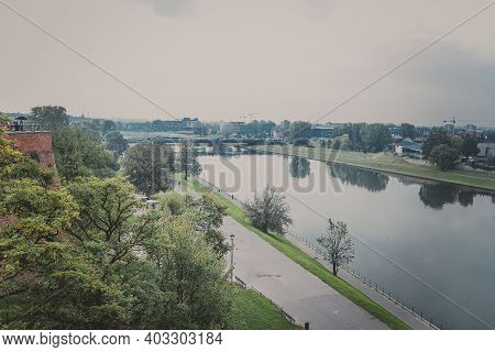 Amaizing View From Wawel Royal Castle On The Park And The Vistula River And Bridge On It In Warm Aut