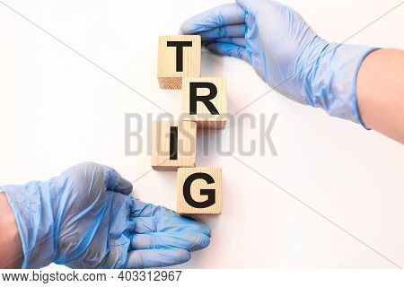 The Doctor Holds Wooden Cubes With Text Trig. The Medicine. Medical Concept