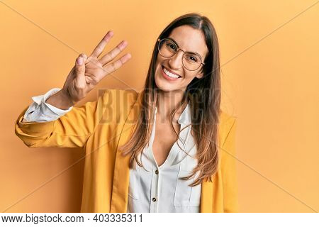 Young beautiful woman wearing business style and glasses showing and pointing up with fingers number three while smiling confident and happy. 