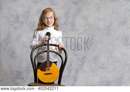Cute Little Girl Learning To Play The Plucked Musical Instrument, Domra.