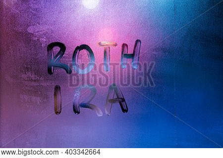 The Words Roth Ira - Individual Retirement Account - Handwritten On Night Wet Window Glass Surface. 
