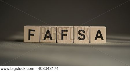 A Wooden Blocks With The Word Fafsa Written On It On A Gray Background.