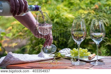 Pouring Of Pinot Gridgio Rose Wine For Tasting In Winery Garden In Veneto, Italy. Glasses Of Cold Dr